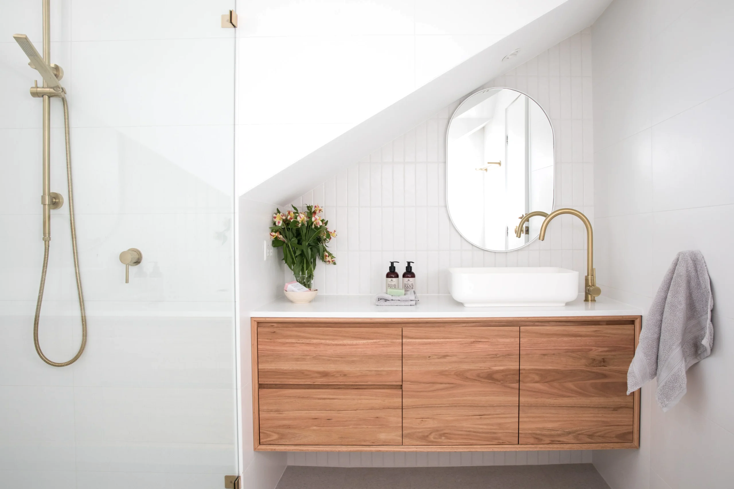Tezgah üstü lavabo, ahşap asma banyo dolabı ve gold batarya ile modern banyo tasarımı